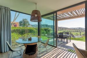jadalnia ze stołem i krzesłami na patio w obiekcie Salobre Villas Lagos w mieście Salobre