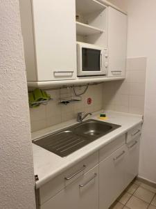 una pequeña cocina con fregadero y microondas en Appartement in Böblingen, en Böblingen