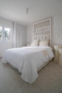 ein großes weißes Schlafzimmer mit einem großen weißen Bett in der Unterkunft Agustino Beach Suites San Agustin in San Agustín