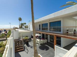 a house with a balcony with a palm tree at Oasis Villas Maspalomas in Maspalomas