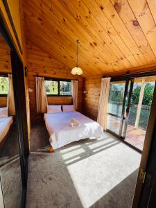 a bedroom with a bed in a wooden cabin at Sunny Beachview Homestay Auckland in Auckland