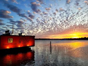 een boot in een lichaam van water met een zonsondergang bij Bamboo Motor Inn in Lakes Entrance +16 foto's