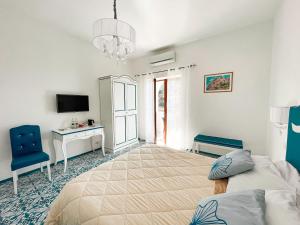 a bedroom with a bed and a desk and a tv at Il Canneto in Positano