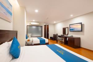 a hotel room with a bed and a desk at Navy Hotel Nha Trang in Nha Trang