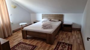 Schlafzimmer mit einem Bett und Holzboden in der Unterkunft Hanul Ancutei in Curtea de Argeş