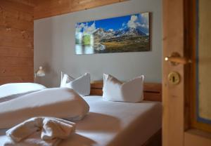 a bedroom with a bed with white sheets and a mountain at Brabander Hütte in Gaschurn