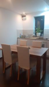 a wooden table with two chairs and a kitchen at Nature apartman in Tata