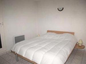 uma cama branca num quarto com uma parede branca em Résidence LES PATIOS 1 - Maisons & Villas pour 6 Personnes 84 em Port Leucate