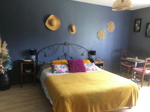 - une chambre avec un lit doté d'un couvre-lit jaune dans l'établissement Le Domaine d'Olène, au Pin