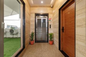 an internal hallway with a door and two potted plants at BluO Studios - Koramangala in Bengaluru