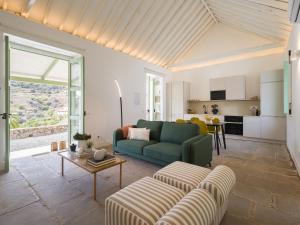 ein Wohnzimmer mit einem grünen Sofa und einem Tisch in der Unterkunft Agroturismo Suites Hacienda los Olivos in Santa Brígida
