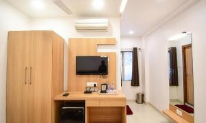 a room with a desk and a tv in a room at FabHotel Stay Inn International in Kolkata