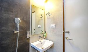 y baño con lavabo y ducha con espejo. en FabHotel Stay Inn International, en Calcuta