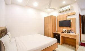 a hotel room with a bed and a tv at FabHotel Stay Inn International in Kolkata