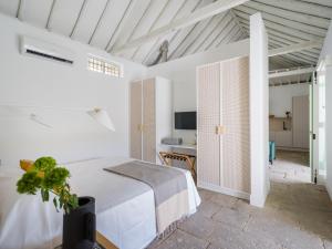 Agroturismo Suites Hacienda los Olivos في سانتا بريخيذا: غرفة نوم بيضاء مع سرير ومكتب