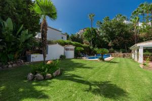 un patio con una palmera y una piscina en VACATION MARBELLA I Villa Faldo, Golf Valley, Private Pool, 24H Security, 10 min from the Marina, en Marbella