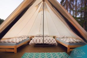 a tent with two beds in a room at Glamping Komarno in Jelenia Góra