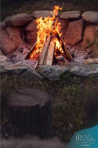 a fire pit with logs and flames in it at Glamping Komarno in Jelenia Góra