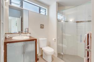 a bathroom with a toilet and a sink and a shower at Lavish Luxury - Parekura Bay Holiday Home in Rawhiti