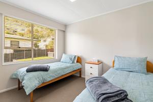 a bedroom with two beds and a window at Seaside Sounds - Picton Upstairs Unit in Picton