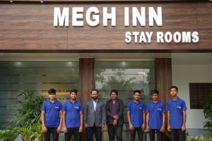 a group of men standing in front of a meeth innstay rooms at MEGH INN in Navi Mumbai