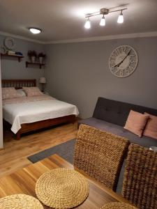 ein Schlafzimmer mit einem Bett und einer Uhr an der Wand in der Unterkunft Apartamenty no3 in Paczków