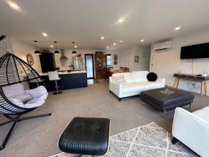 un soggiorno con divano e sedia di Naseby Modern Home a Naseby