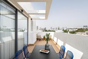 a room with a table and chairs on a balcony at Mate GEORGE - By HOMY in Tel Aviv