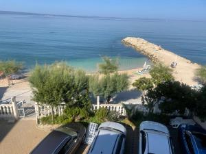 un grupo de coches estacionados junto a una playa en Apartments Petričević, en Podstrana