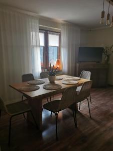 une table à manger avec des chaises et une télévision dans l'établissement Apartamenty no3, à Paczków