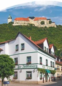 um edifício branco com um castelo no topo de uma colina em Pension Zur Neuenburg em Freyburg