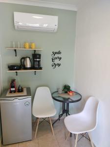 uma cozinha com uma mesa e duas cadeiras brancas em Anassa Deluxe Apartments & Studios em Skala Potamias