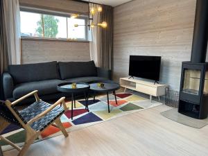 sala de estar con sofá y TV en Salmons väg Funäsdalen, en Funäsdalen