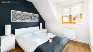 a bedroom with a white bed and a black wall at Wonder Home - Domki górskie z kominkami na kameralnym osiedlu - plac zabaw na terenie kompleksu in Karpacz +129 photos