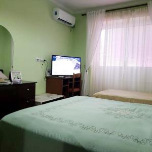 a bedroom with a bed and a flat screen tv at Malsi 2 Bedrooms Apartment in Vlorë