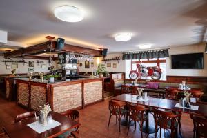 um restaurante com mesas e cadeiras e um bar em Hotel Zlatá Hvězda em Vimperk