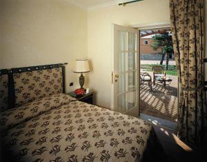 1 dormitorio con 1 cama y patio con mesa en ALTAFIUMARA ISOLE 4*, en Cannitello