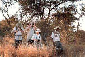 un groupe de personnes prenant des photos dans un champ dans l'établissement Gabus Safari Lodge, à Otavi