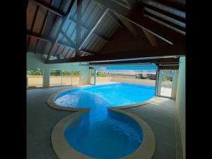 a large swimming pool with blue water in a building at Balnearia - Appt avec piscine partagée in Montauban-de-Luchon