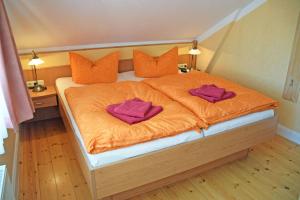uma cama com duas toalhas roxas em cima em Villa Vitalis Ferienhaus Vitale em Ostseebad Sellin