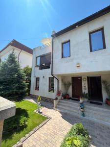 ein Haus mit zwei Kindern, die draußen stehen in der Unterkunft Vila AlMare in Eforie Nord