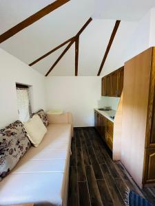 a living room with a white couch and a kitchen at Studio Apartment in Bihać