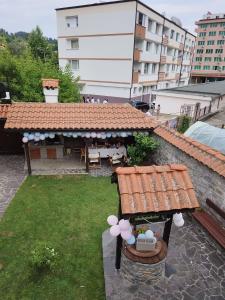 a garden with a table and a bench with flowers on it at Guest house "The House" in Zlatograd