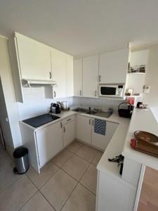 - une petite cuisine avec des placards blancs et un comptoir dans l'établissement CREVETTE Gezellig appartement met zonnige terrassen en zeezicht - Toplocatie!, à Coxyde