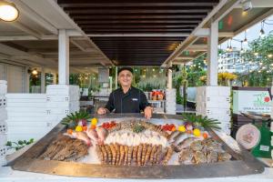 a man standing in front of a table of food at Kantary Bay Hotel Phuket in Panwa Beach
