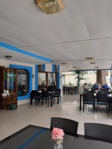 Sevo Hotel في أيفاليك: مطعم بالطاولات والكراسي والناس جالسين على الطاولات
