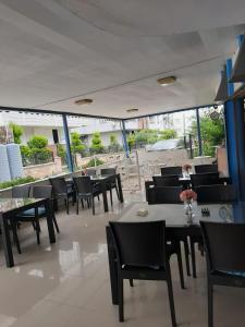 Sevo Hotel في أيفاليك: غرفة طعام مع طاولات وكراسي ونوافذ