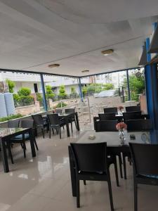 a dining room with tables and chairs and windows at Sevo Hotel in Ayvalık
