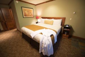 a bedroom with a large bed with a dress on it at Avalon Lodge South Lake Tahoe in South Lake Tahoe