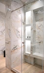 W łazience znajduje się prysznic ze szklanymi drzwiami. w obiekcie By The Lake w mieście Kastoria